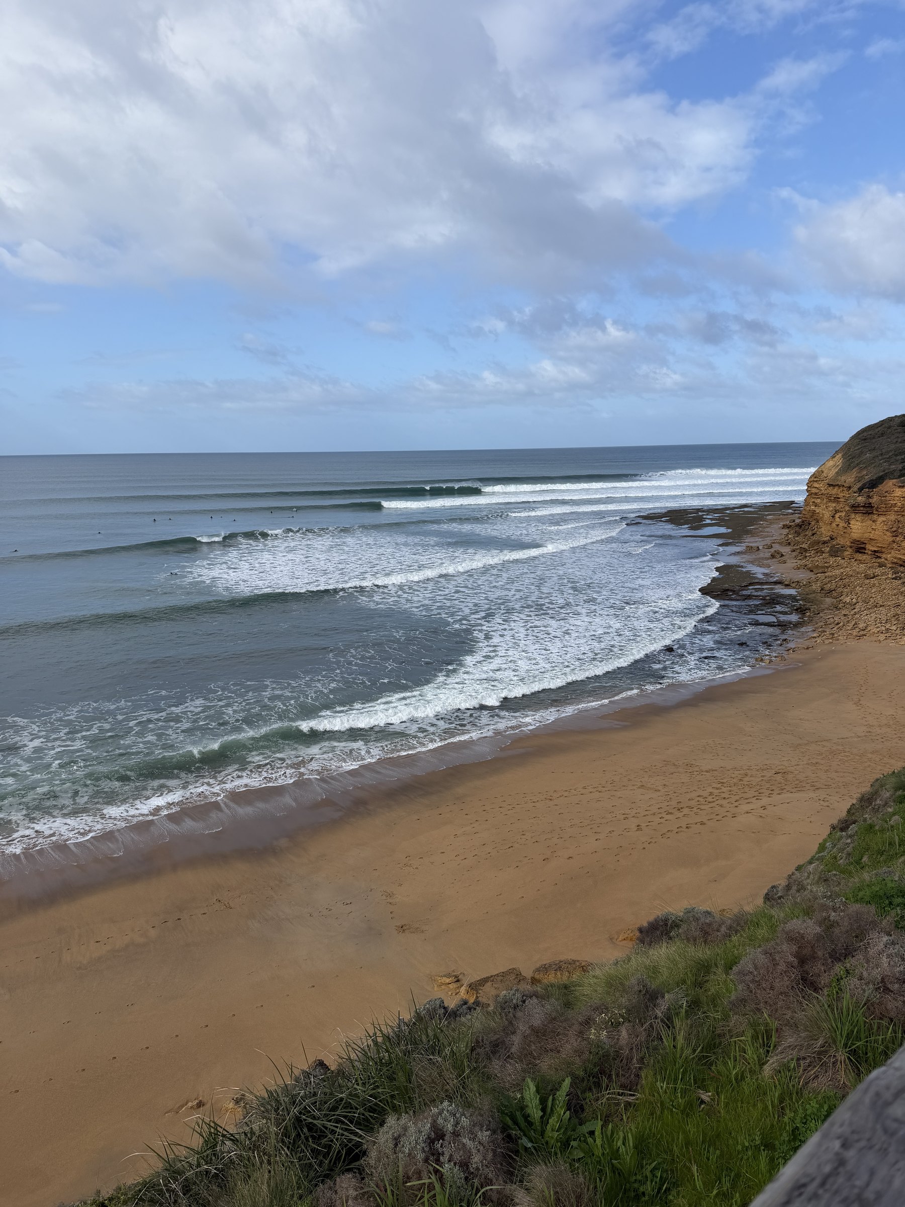 A beach with clean waves rolling in on a sunny morning.